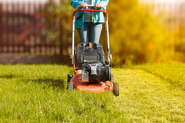 woman working with a lawnmower
